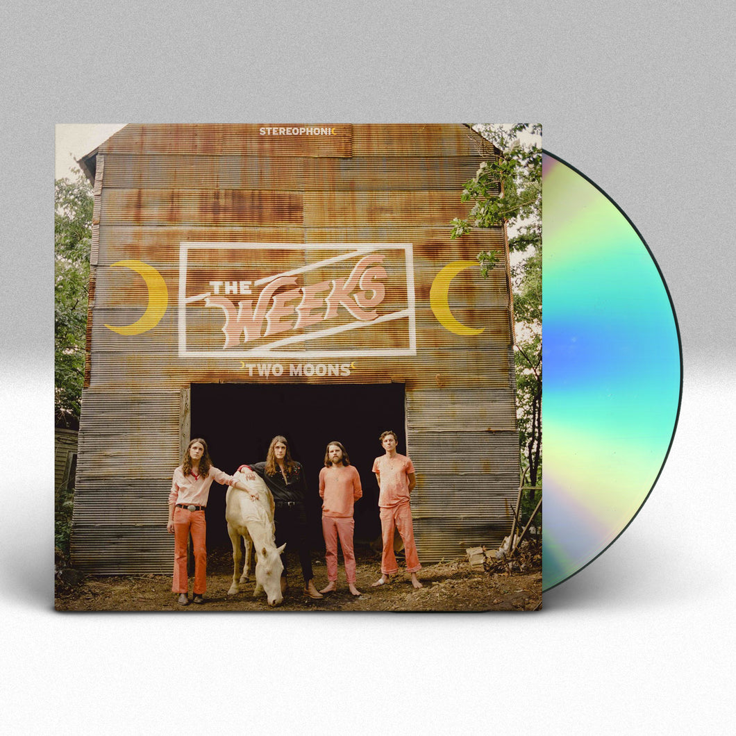 Image of a cd sleeve with a cd sticking halfway out of the sleeve against a grey to white gradient background. The album cover features an image of the 4 members of the weeks standing next to a white horse that is eating off from the ground. They are standing in front of a barn in a wooded area. Above the entryway to the barn in a white rectangle are the words the weeks in the color pink. Next to the rectangle are yellow crescent moons, one on each side. below that in white text it says two moons.
