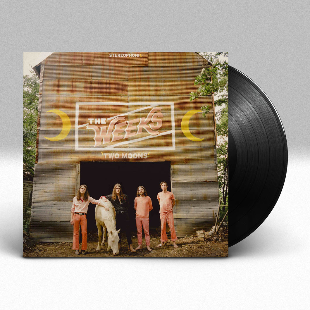 Image of a vinyl sleeve with a solid black vinyl sticking halfway out of the sleeve against a grey to white gradient background. The album cover features an image of the 4 members of the weeks standing next to a white horse. They are standing in front of a barn in a wooded area. Above the entryway to the barn in a white rectangle are the words the weeks in the color pink. Next to the rectangle are yellow crescent moons, one on each side. below that in white text it says two moons.