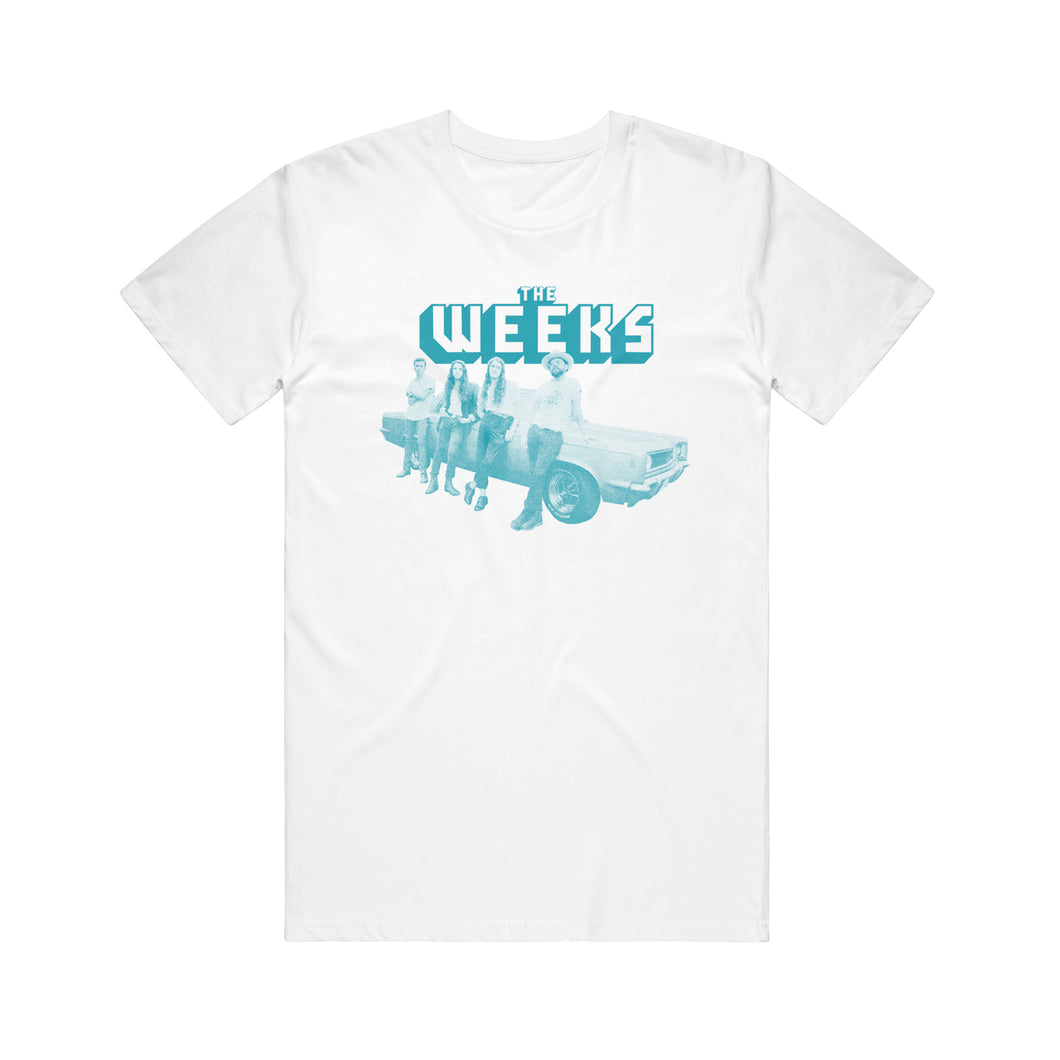 Image of a white tshirt against a white background. The center of the shirt says the weeks in white and teal block letters. Below that is an image in teal and white of the 4 members of the weeks leaning up against a classic car. 